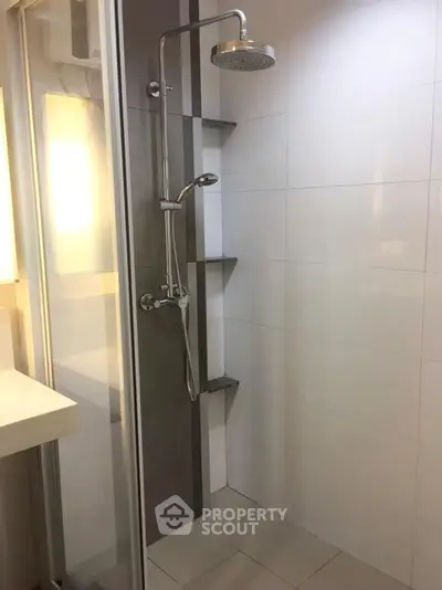 Modern bathroom with sleek shower design and glass enclosure in contemporary apartment.