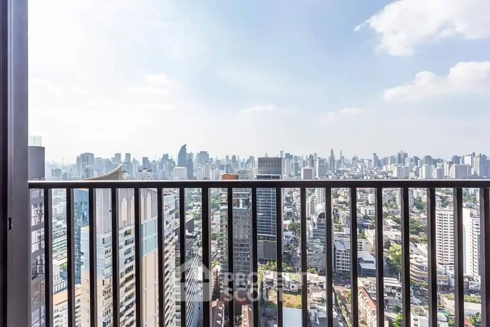 Stunning cityscape view from a high-rise balcony, showcasing urban skyline and clear blue sky.