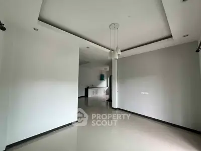 Spacious modern living room with sleek design and elegant lighting fixtures.