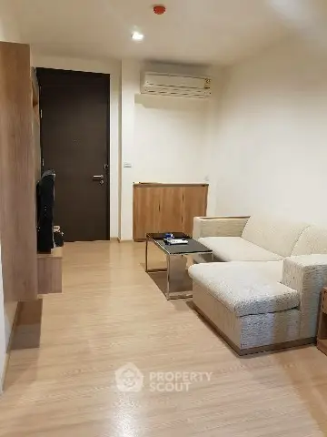 Modern living room with sleek wooden flooring and cozy beige sofa
