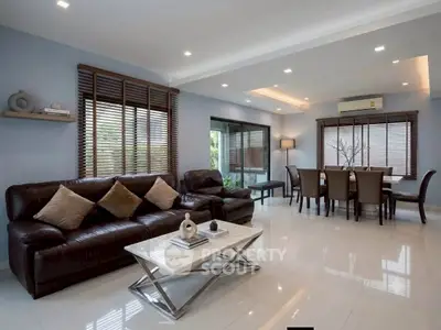 Spacious modern living room with elegant dining area and large windows.