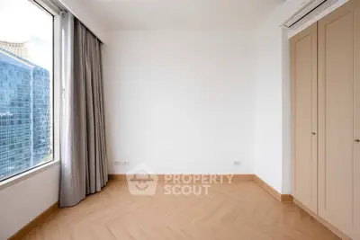 Bright empty room with large window and city view, perfect for customization.