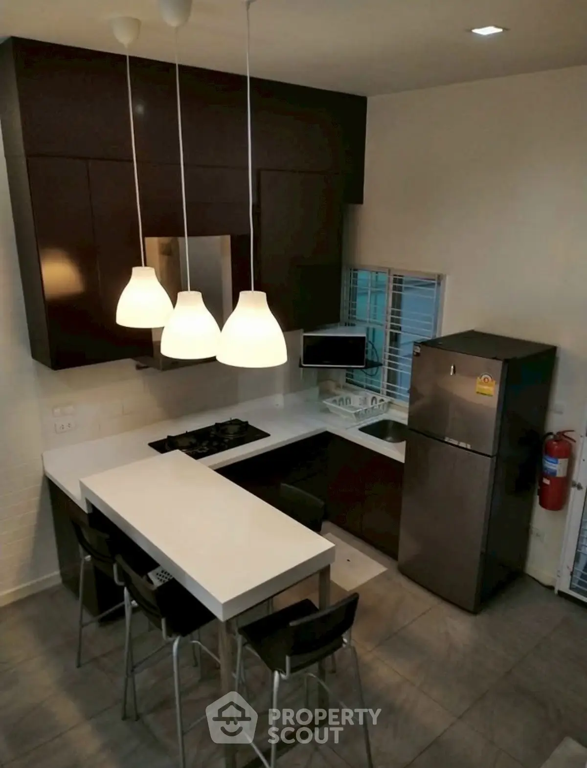 Modern kitchen with sleek design, featuring island counter and contemporary lighting.
