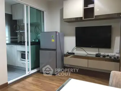 Modern living room with sleek TV setup and compact kitchen view