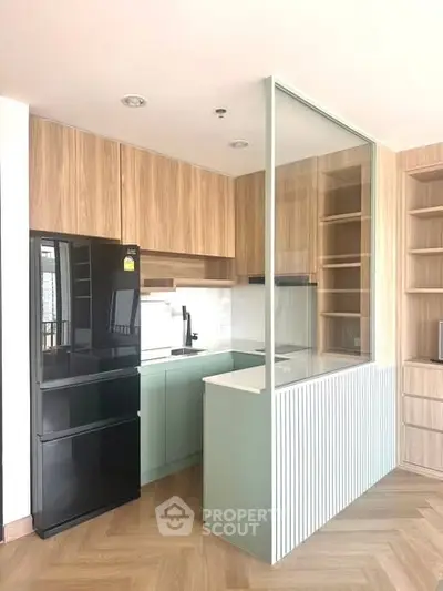 Modern kitchen with sleek black fridge and stylish cabinetry in open layout