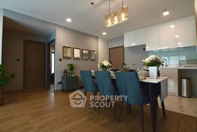Spacious dining area with elegant decor and modern kitchen in open layout apartment.