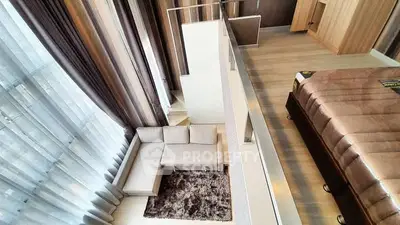 Luxurious loft-style bedroom with floor-to-ceiling windows and cozy living area.