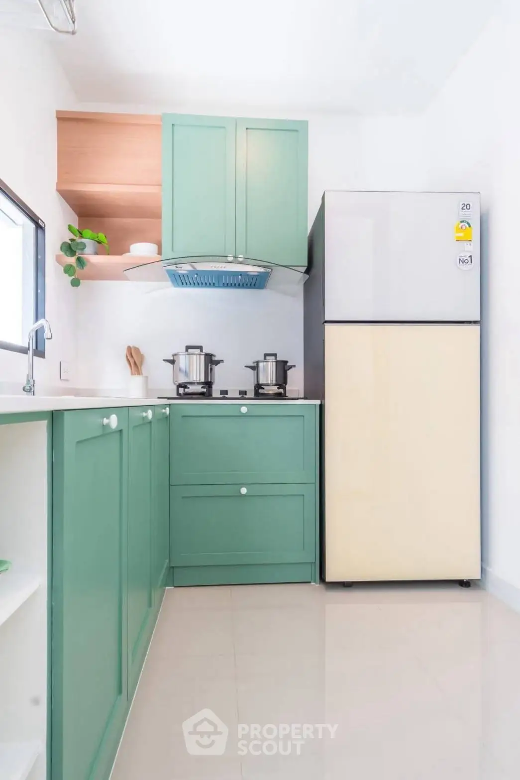 Modern kitchen with green cabinets and sleek appliances in a bright, minimalist design.