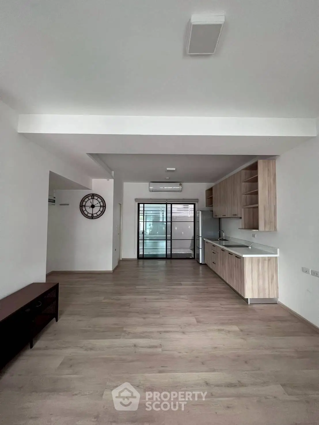 Spacious open-plan living room with modern kitchen and wooden flooring