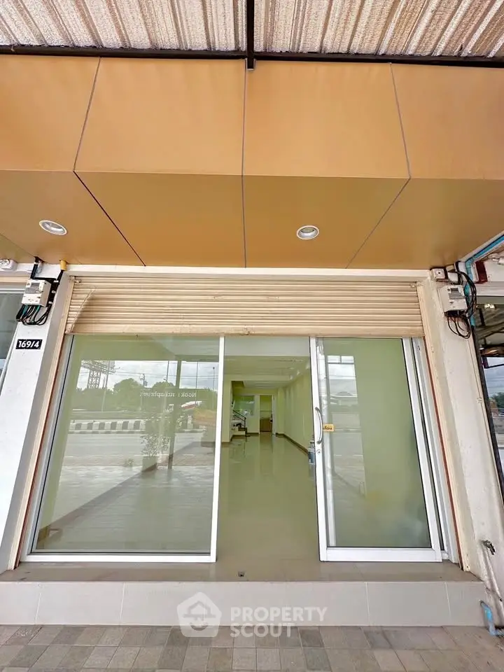 Commercial property with glass facade and roll-up shutter, ideal for retail or office space.