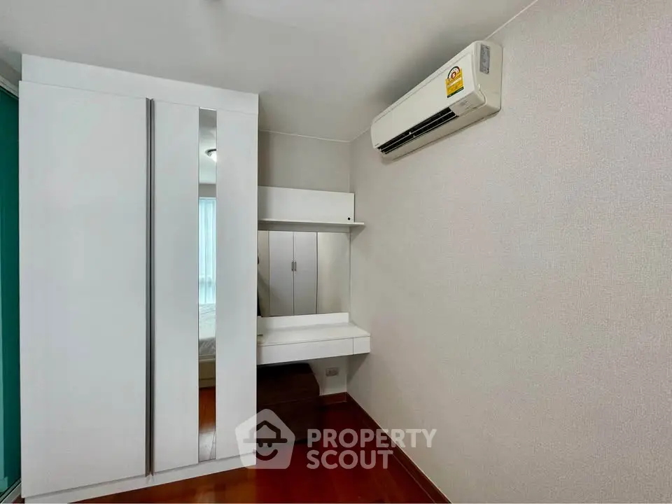 Modern bedroom with sleek wardrobe and air conditioning unit