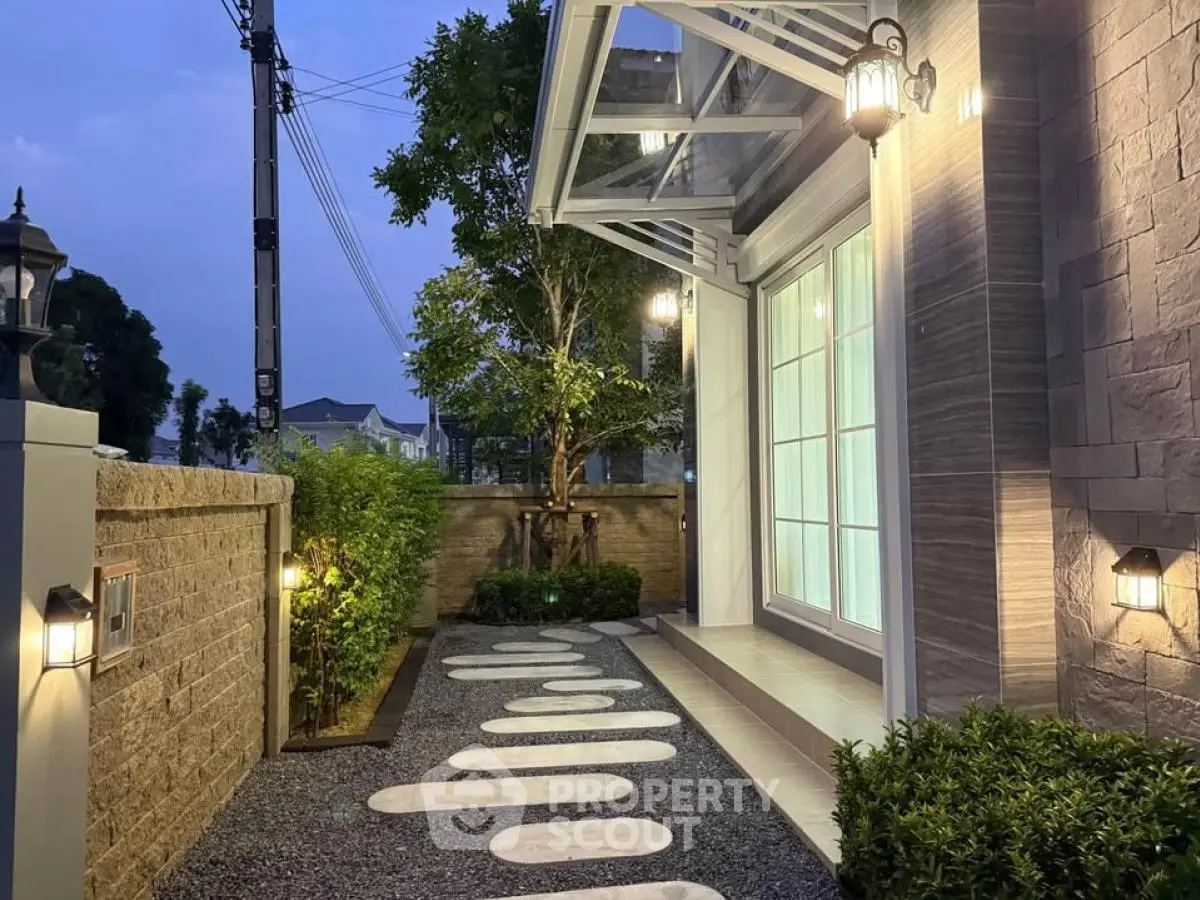 Charming exterior view of modern home with stylish pathway and ambient lighting.