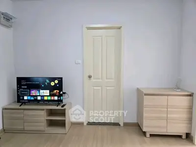 Modern living room with sleek TV setup and minimalist furniture design.