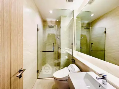 Luxurious modern bathroom with glass shower and sleek fixtures in upscale property.