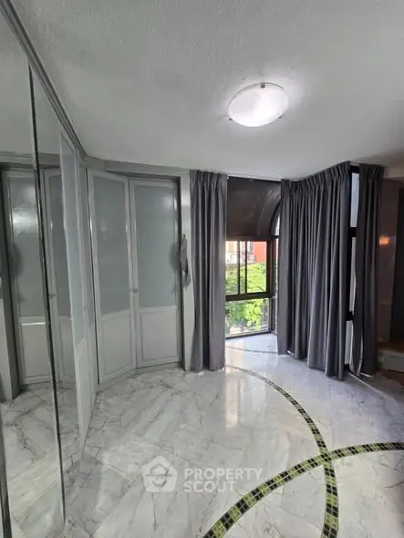 Spacious room with marble flooring and large windows for natural light