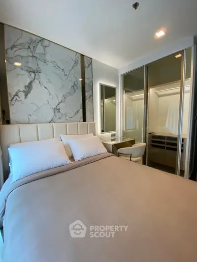 Luxurious bedroom with marble accent wall and mirrored wardrobe