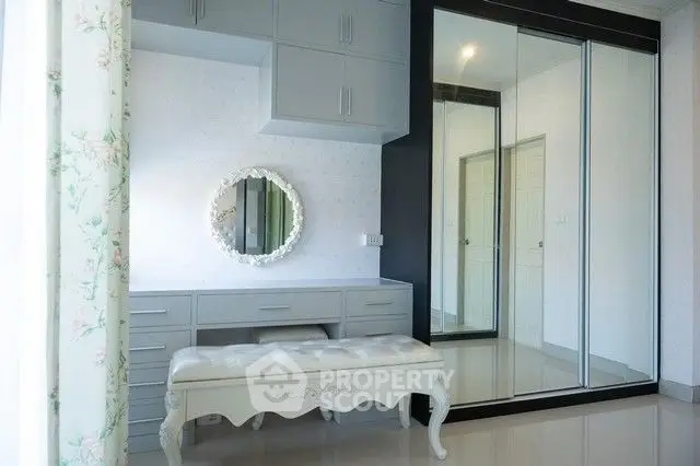 Elegant bedroom with mirrored closet and vintage vanity bench