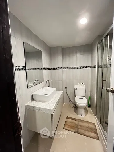 Modern bathroom with sleek fixtures and glass shower enclosure