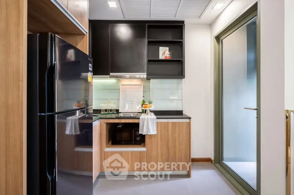 Modern kitchen with sleek cabinetry and large window for natural light.