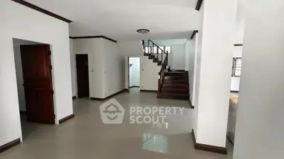 Spacious interior with polished floors and wooden staircase in modern home