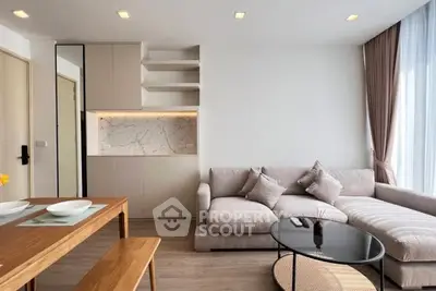 Modern living room with cozy sectional sofa and elegant dining area, featuring stylish decor and natural light.