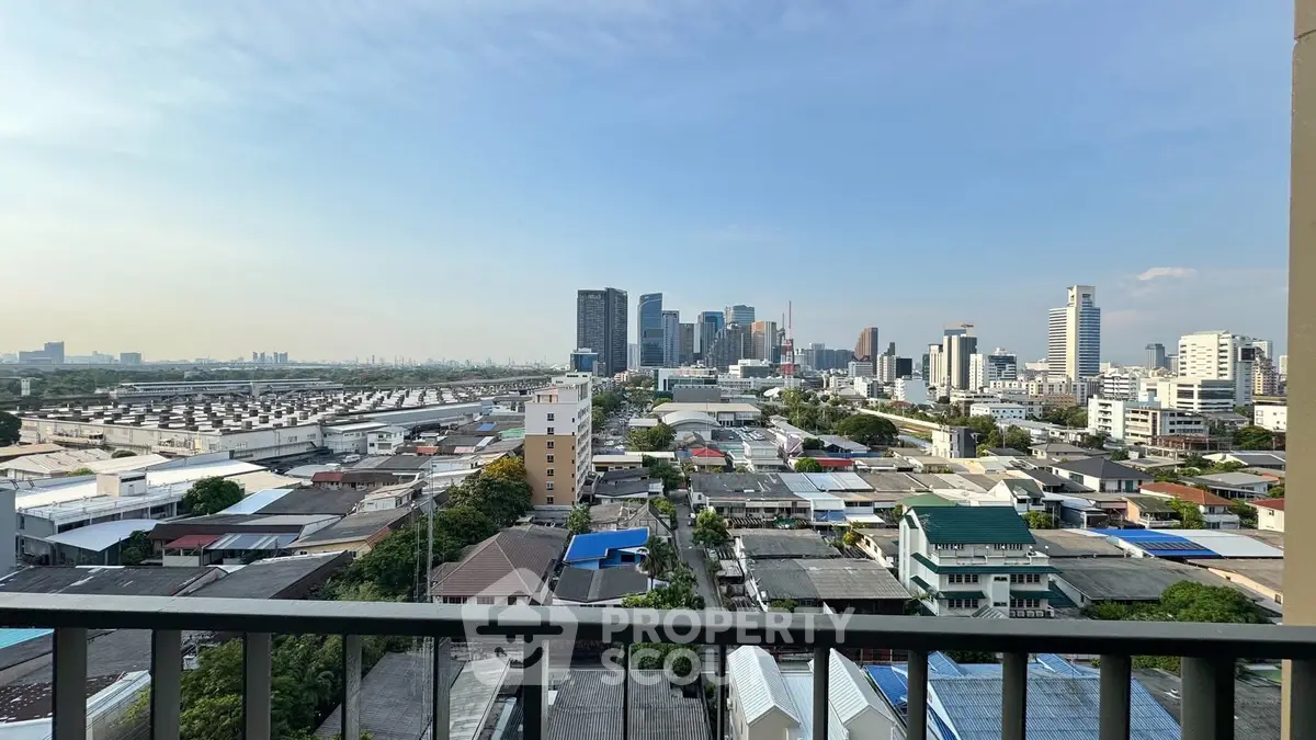 Stunning cityscape view from a high-rise balcony overlooking urban skyline and residential area.