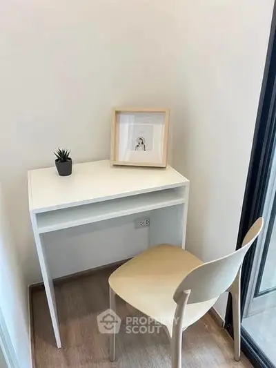 Cozy study nook with modern desk and chair by a window, perfect for productivity.
