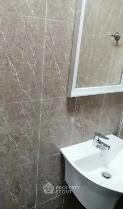 Modern bathroom with elegant marble tiles and sleek white sink