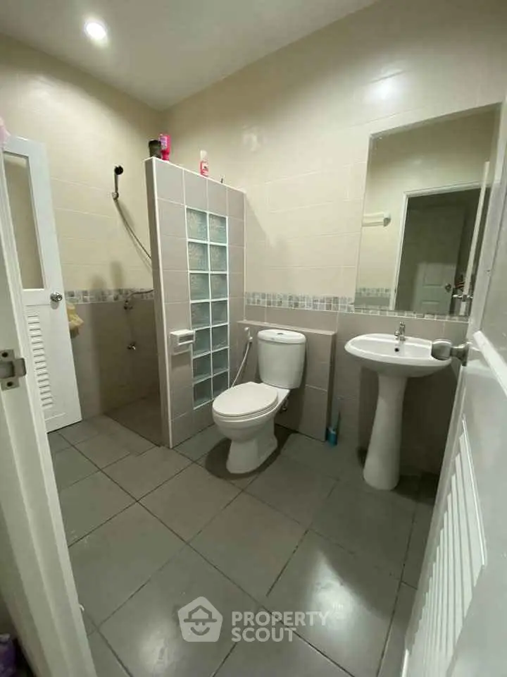 Modern bathroom with glass block partition and sleek fixtures