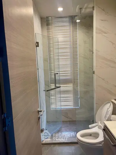 Modern bathroom with glass shower and marble accents