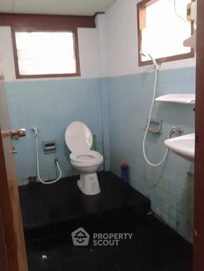 Cozy bathroom with blue tiles and essential fixtures, perfect for a compact living space.