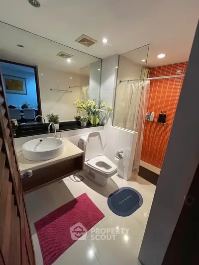 Modern bathroom with stylish fixtures and vibrant red accent wall