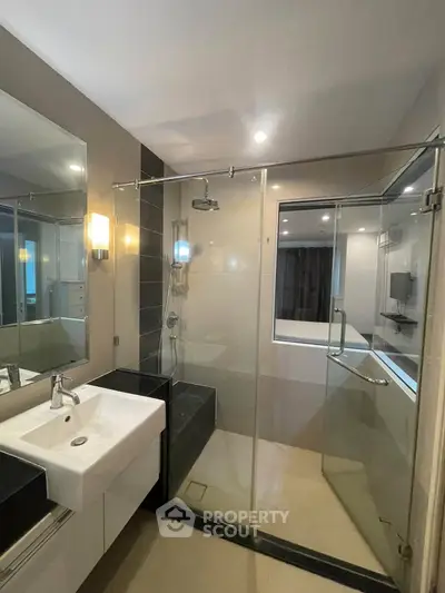 Modern bathroom with glass shower enclosure and sleek fixtures