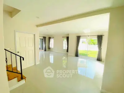 Spacious and bright living room with large windows and garden view