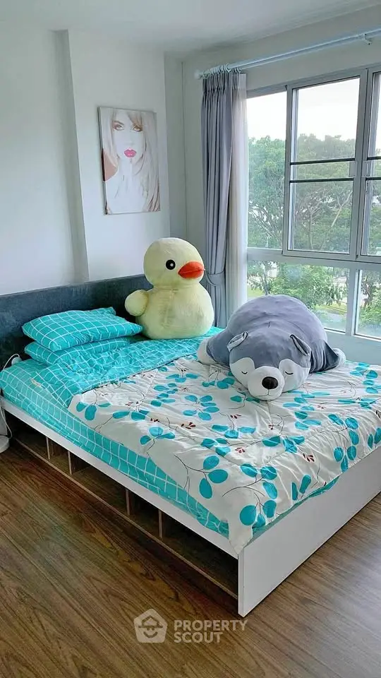 Bright bedroom with large windows and playful stuffed animals on the bed.