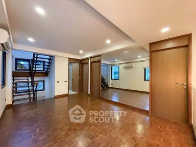 Spacious modern living room with wooden flooring and mirrored wall