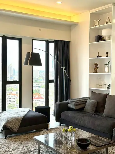 Modern living room with city view, stylish decor, and cozy seating area.