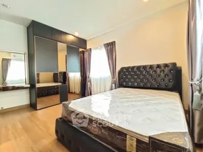Luxurious bedroom with elegant black furniture and large windows for natural light.