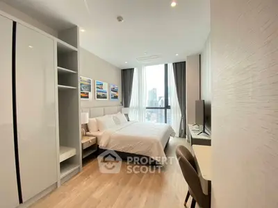 Modern bedroom with city view, stylish decor, and ample natural light in a high-rise apartment.