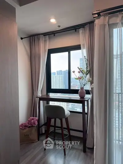 Chic study nook with city view, featuring elegant curtains and stylish decor, perfect for urban living.