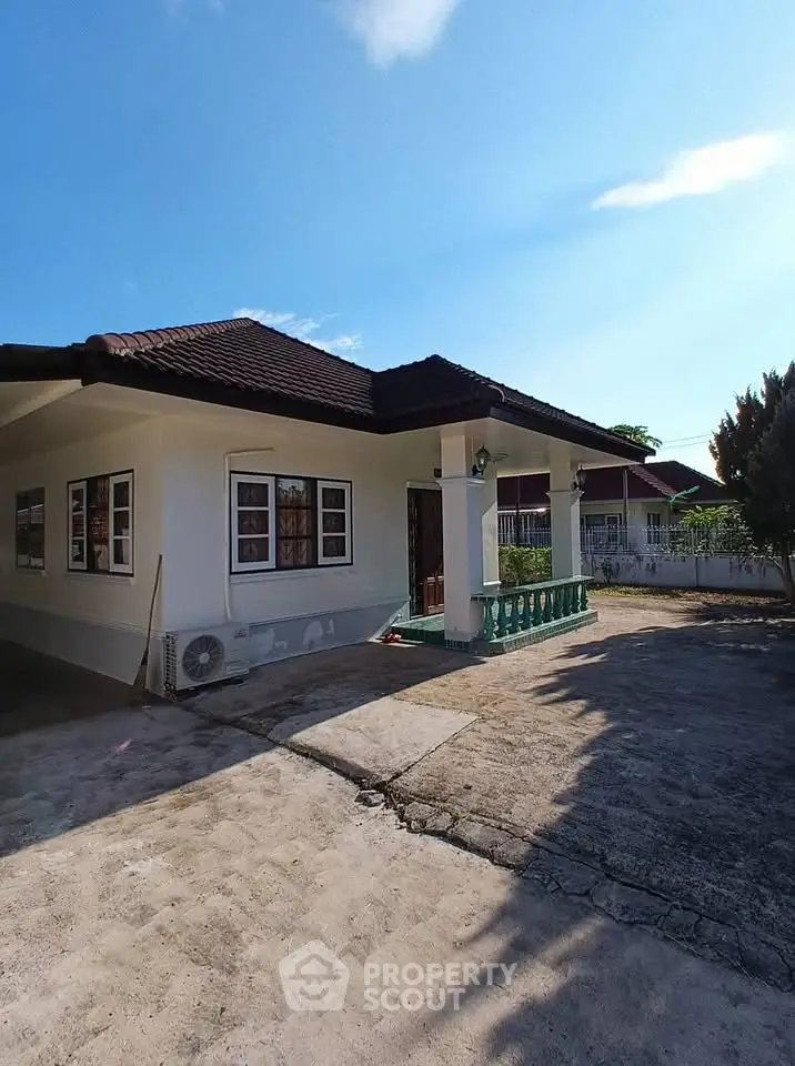 Charming single-story house with spacious driveway and inviting front porch.