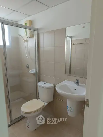 Modern bathroom with glass shower and sleek fixtures in a contemporary apartment.