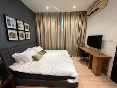 Modern bedroom with stylish decor, featuring a comfortable bed, wall art, and a sleek desk with a TV.