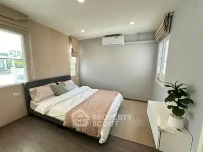Spacious bedroom with modern decor and natural light, featuring a comfortable bed and stylish furnishings.