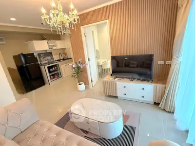 Elegant living room with chandelier and modern kitchen in open layout