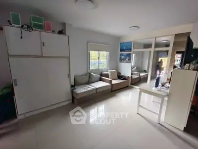 Spacious living room with modern furniture and large window for natural light.