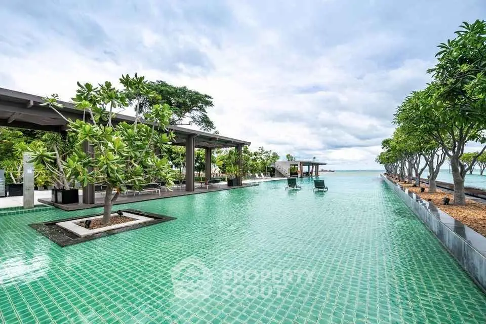 Luxurious beachfront pool with stunning ocean view and lush greenery.
