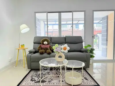 Charming living room with plush sofa, large windows, and stylish decor for a cozy ambiance.