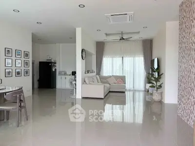 Spacious modern living room with elegant decor and large windows offering natural light.