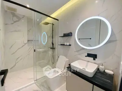 Luxurious modern bathroom with marble tiles and illuminated mirror